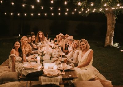 Backyard party using string lighting over a low boho table.