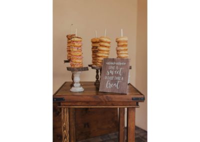 Farmhouse cocktail table used as a donut dessert table at a wedding reception