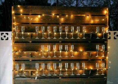 Champagne pallet wall lit up at backyard wedding in Arizona
