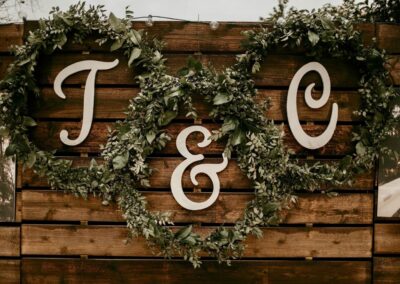 Laser cut wooden letter cut outs on pallet wall backdrop.