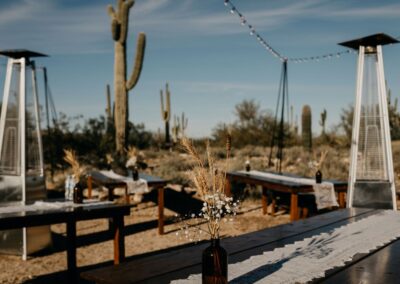 Pyramid Space Heaters under Bistro Lighting surrounded by Classic Farmhouse Tables at outdoor desert wedding in Arizona
