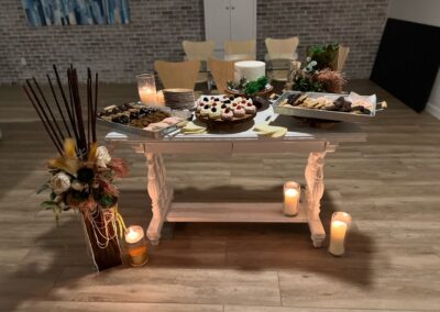 small white accent table with desserts at wedding