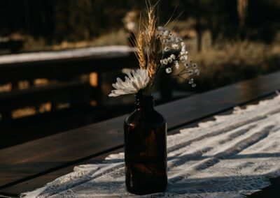 small floral arrangement in a brown apothecary bud vase on a lacy table runner