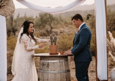 bride and groom during wedding ceremony standing at a wine barrel table