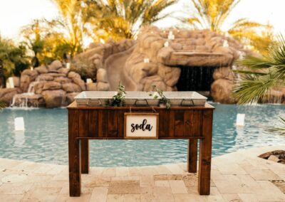 wood stand with three galvanized tubs set in a backyard wedding