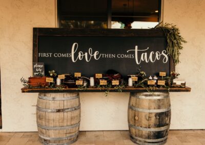 table made of two wine barrels set up with food and a large chalkboard sign