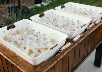 Wood stand with three white buckets holding sodas and ice