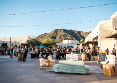 Guests standing under string lighting at an outdoor wedding