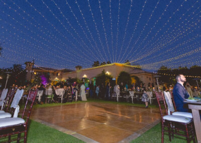 Twinkle string lights strung above guests at an outdoor wedding reception