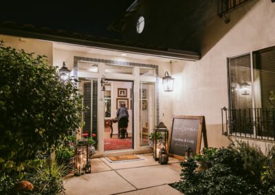 A welcome sign written on a wood chalkboard at the entrance to a wedding at a private residence