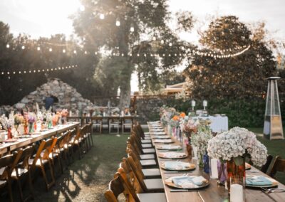 Wood farm table at outdoor venue with floral centerpiece