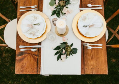Overhead shot of wood farm table with elegant table runner and floral centerpiece